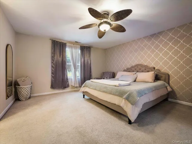 a spacious bedroom with a bed and a chandelier