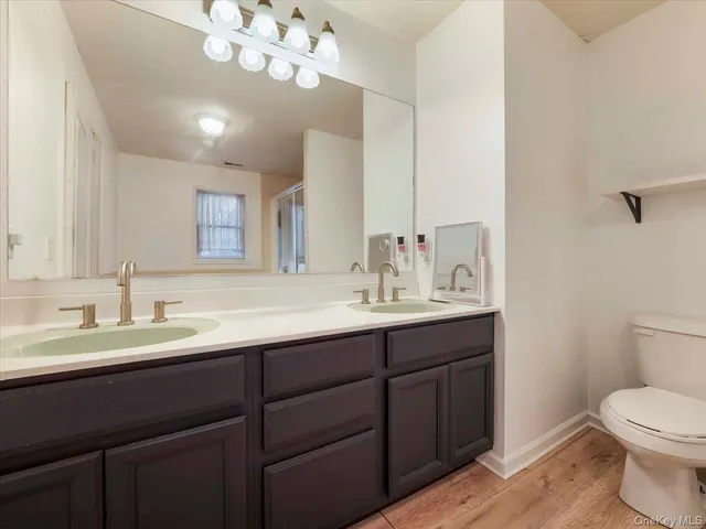 a bathroom with a sink a toilet and a mirror