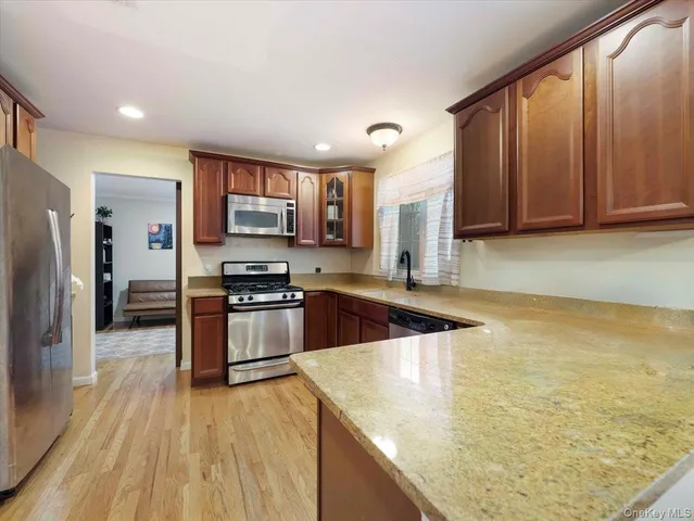 a kitchen with stainless steel appliances granite countertop a stove a sink and a refrigerator