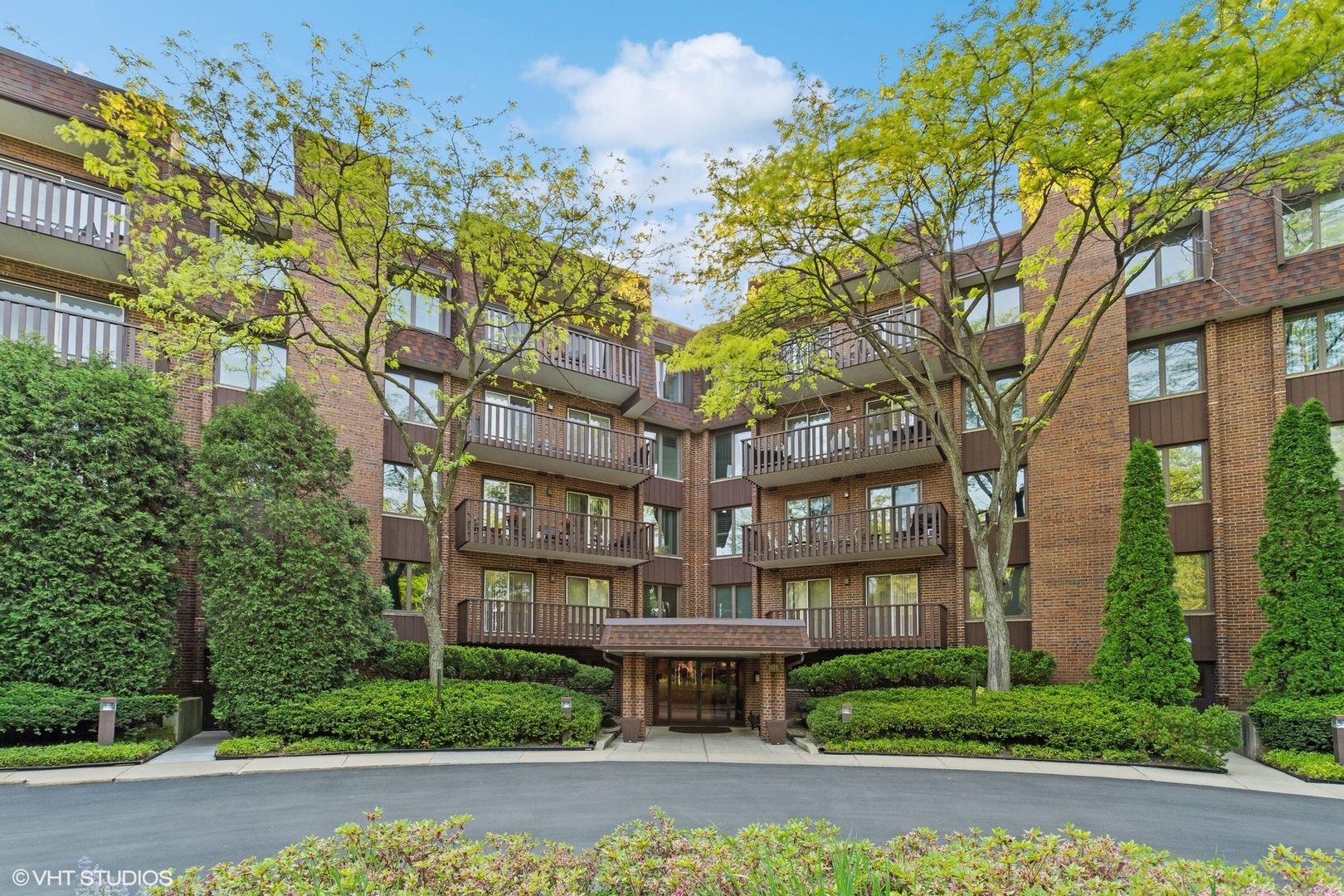 1175 Lake Cook Road, Unit 204 Northbrook, IL 60062 - Photo 1 of 20 a front view of a building with a garden and fountain