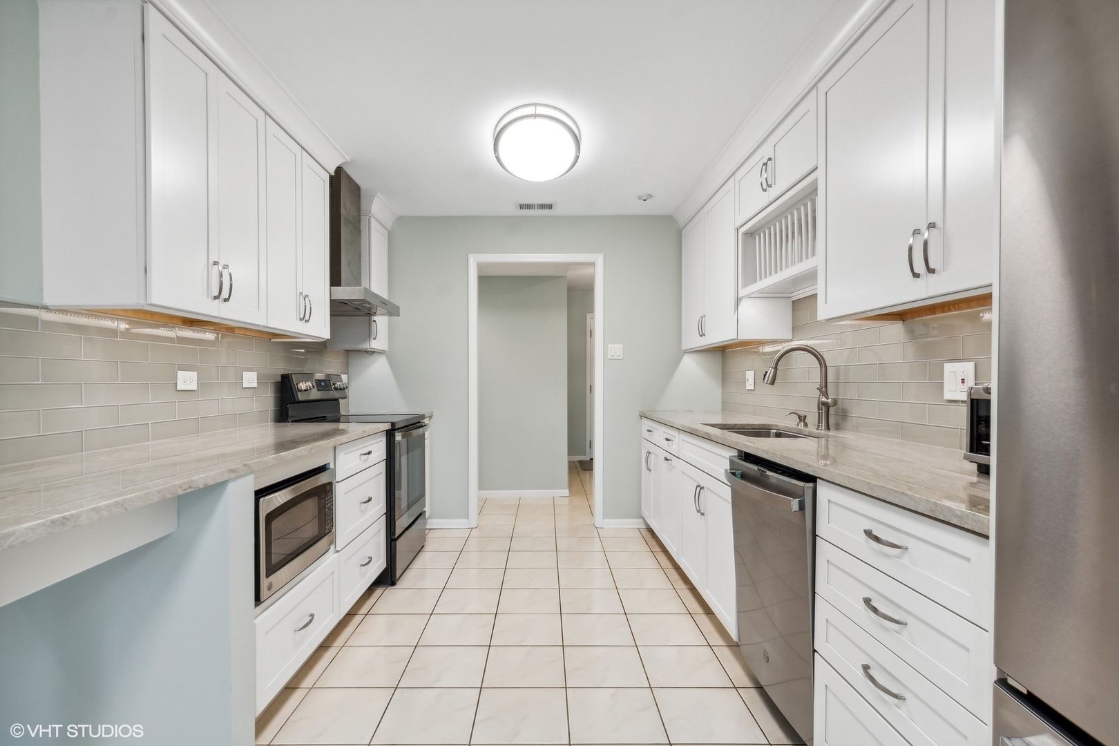 1175 Lake Cook Road, Unit 204 Northbrook, IL 60062 - Photo 9 of 20 a kitchen with granite countertop white cabinets and white appliances