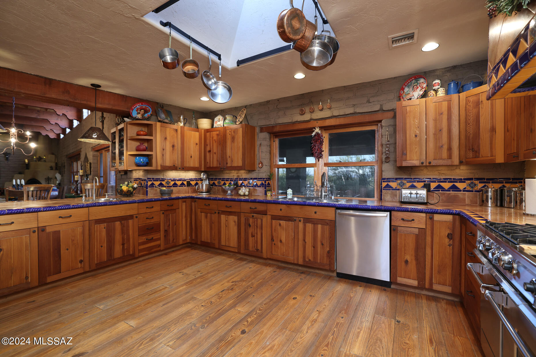 11725 East Spanish Ridge Place Tucson, AZ 85730 - Photo 19 of 51 a kitchen with stainless steel appliances granite countertop a large stove a sink dishwasher and a microwave oven with wooden floor