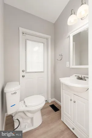 a bathroom with a toilet a sink a vanity and mirror