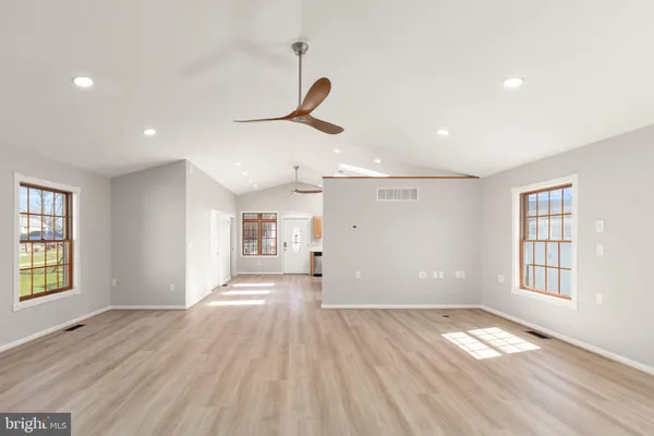 a view of empty room with wooden floor and windows
