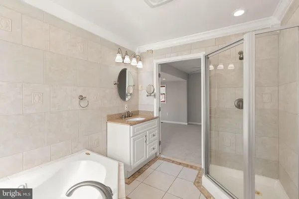 a bathroom with a granite countertop tub a sink and a large mirror