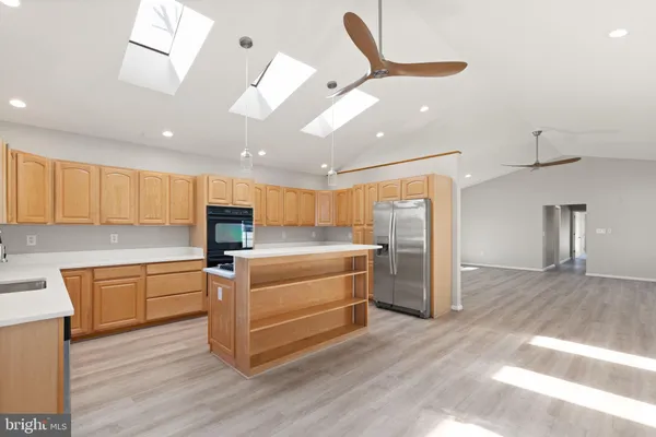 a kitchen with stainless steel appliances kitchen island granite countertop a refrigerator and a stove top oven