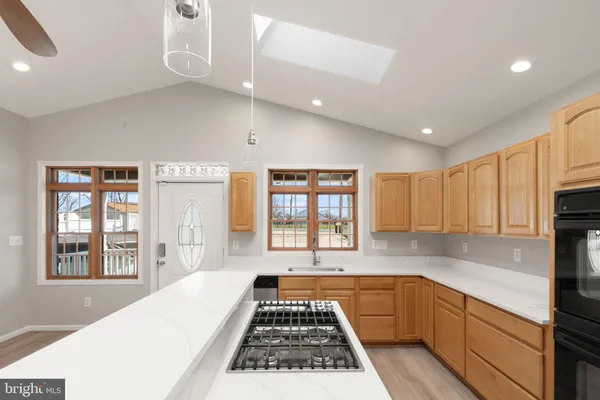 a kitchen with a large window appliances and cabinets