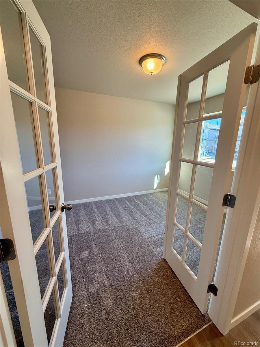 757 North Clubview Street Watkins, CO 80137 - Photo 24 of 24 a view of an empty room with wooden floor and entryway