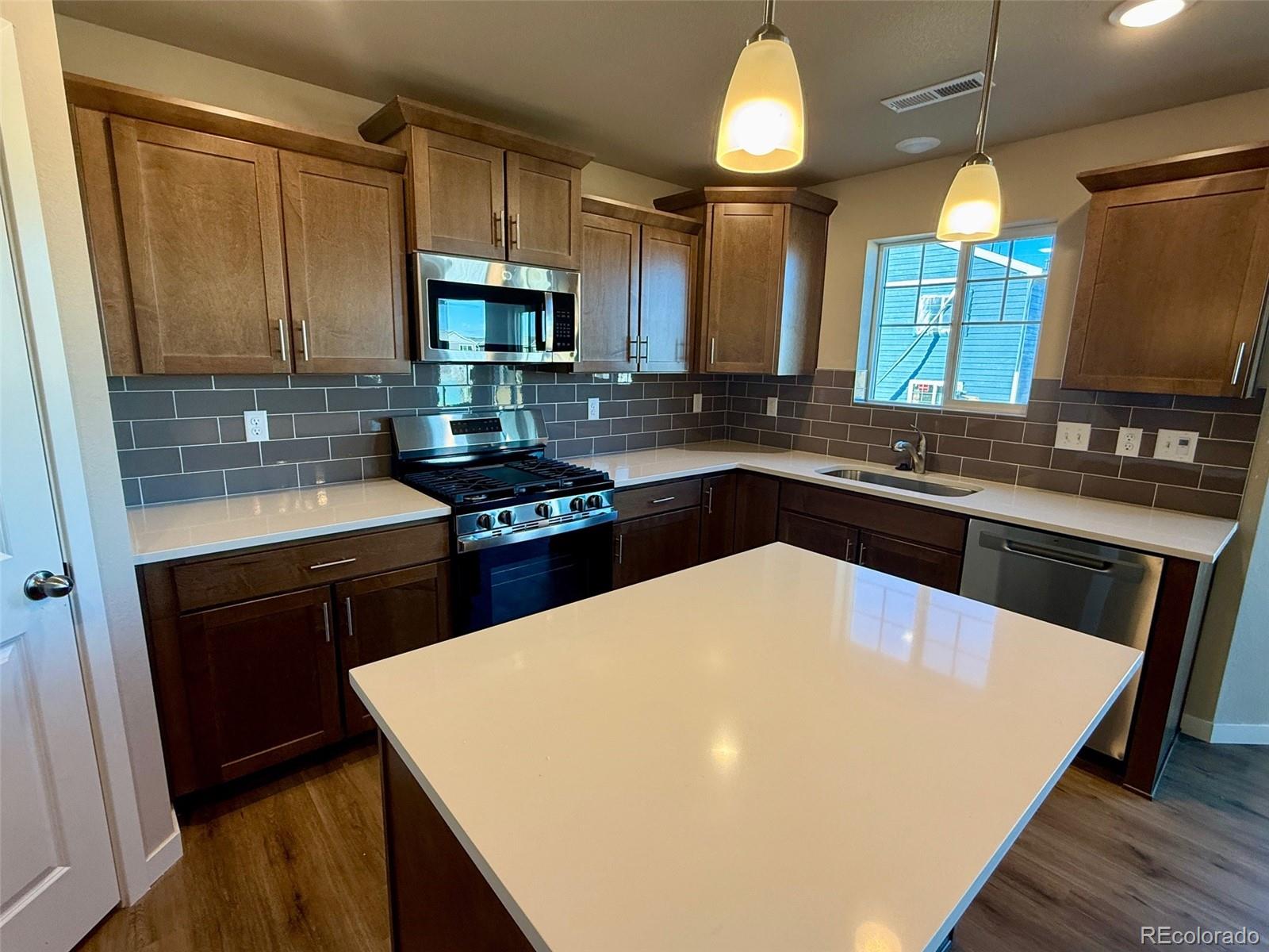 757 North Clubview Street Watkins, CO 80137 - Photo 4 of 24 a kitchen with a sink a stove and cabinets