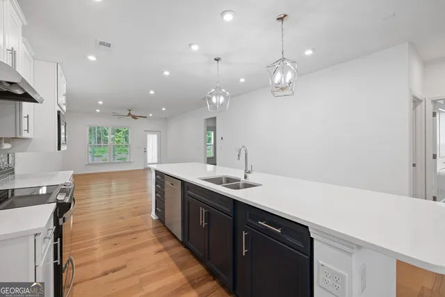 a large kitchen with kitchen island a sink stainless steel appliances and a counter top space