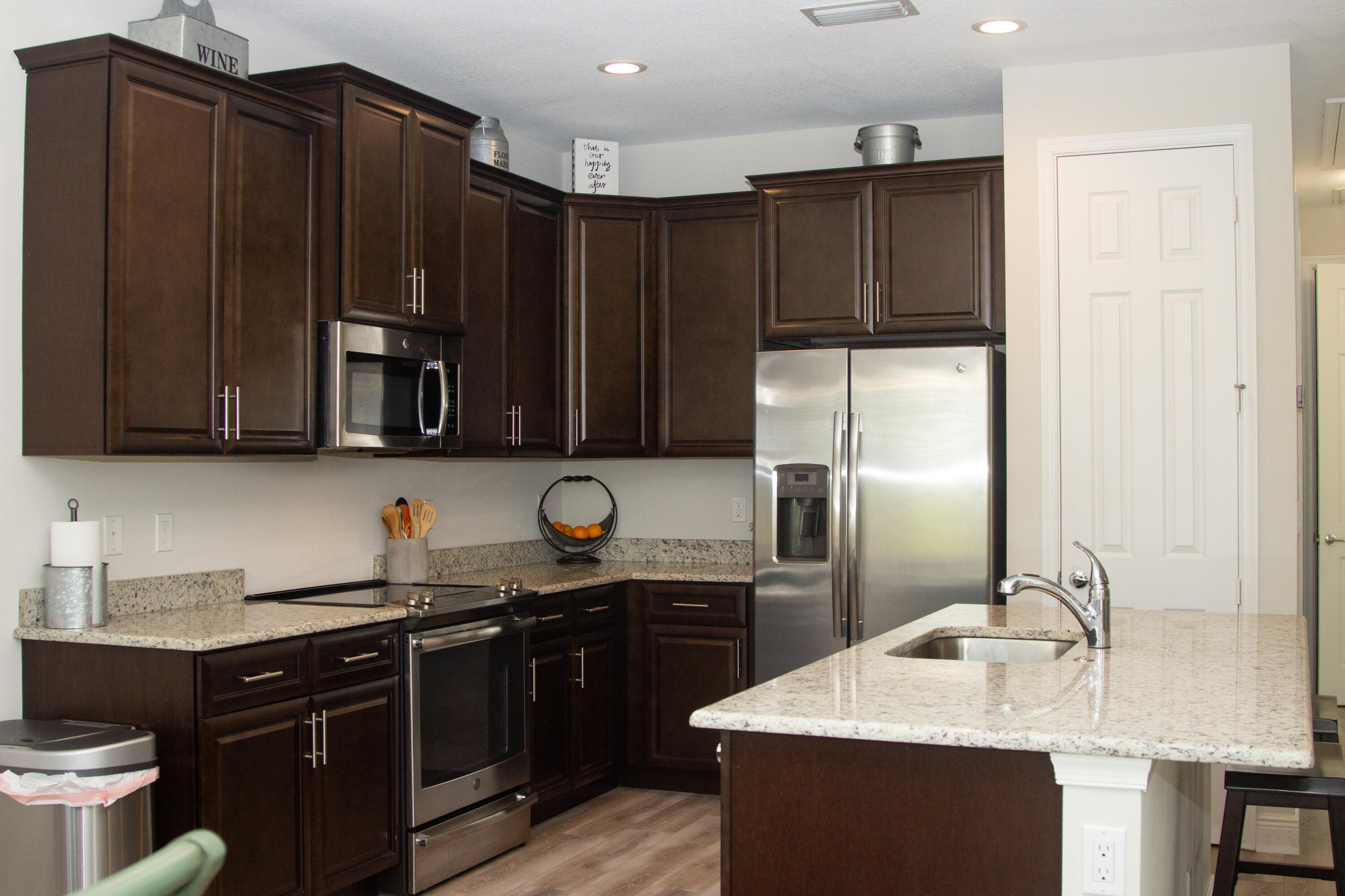 12601 57th Road North West Palm Beach, FL 33411 - Photo 9 of 24 a kitchen with kitchen island granite countertop a sink cabinets and stainless steel appliances