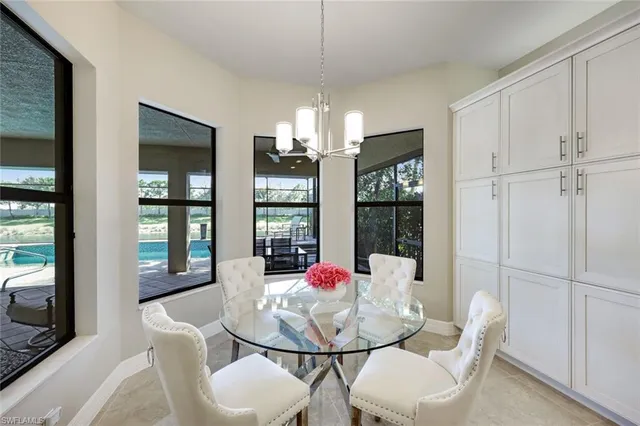 a dining room with furniture a chandelier and window