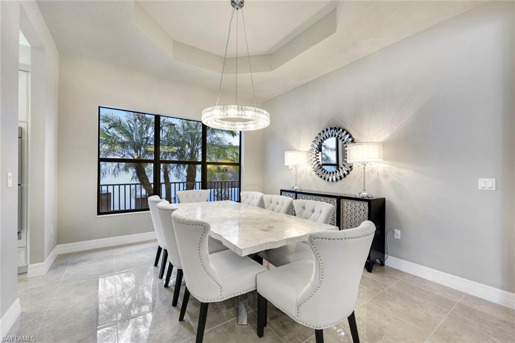 4394 Caldera Circle Naples, FL 34119 - Photo 15 of 39 a view of a dining room with furniture a chandelier and window