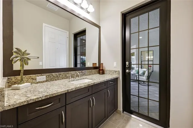 a bathroom with a granite countertop sink and mirror