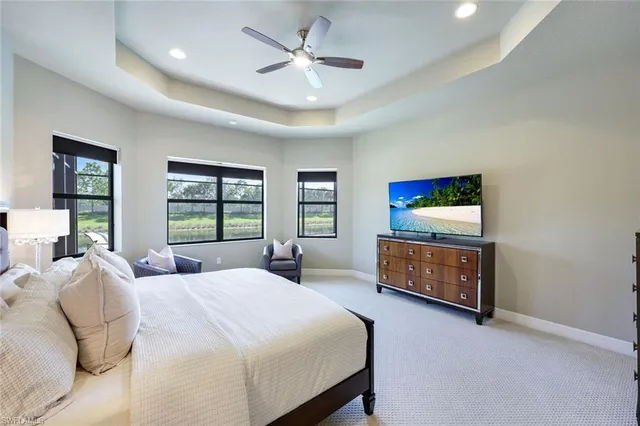 a bedroom with a bed a window and a flat screen tv