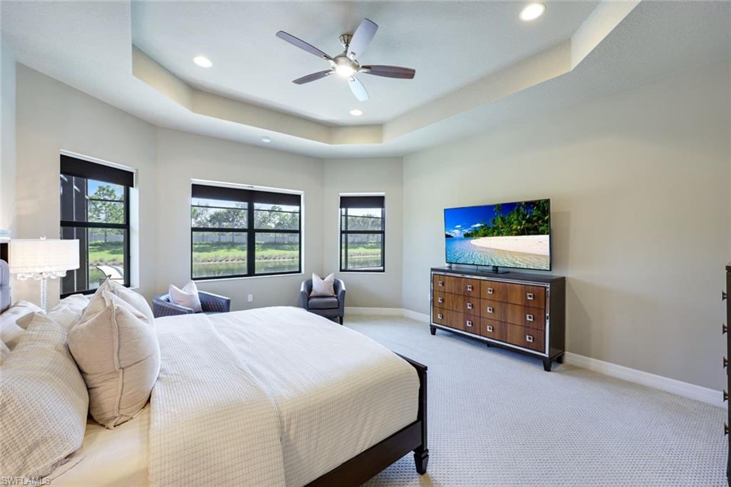 4394 Caldera Circle Naples, FL 34119 - Photo 18 of 39 a bedroom with a bed a window and a flat screen tv