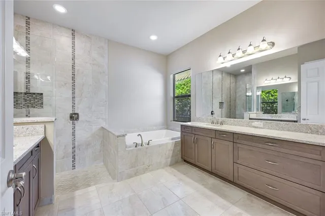 a spacious bathroom with a tub sink shower and mirror
