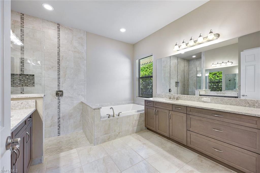 4394 Caldera Circle Naples, FL 34119 - Photo 20 of 39 a spacious bathroom with a tub sink shower and mirror