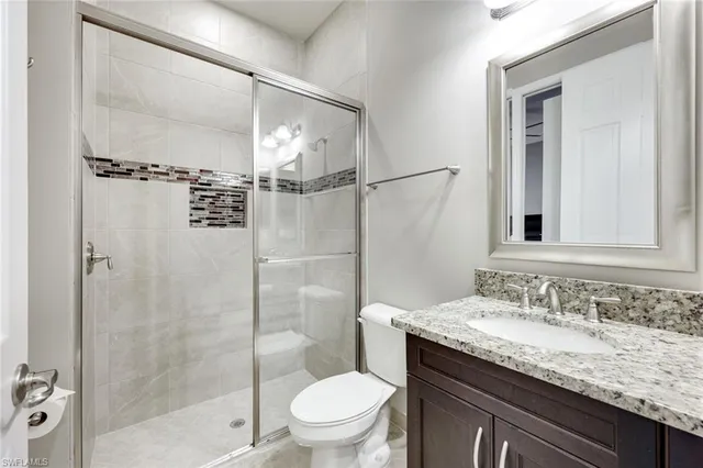 a bathroom with a granite countertop sink toilet and shower