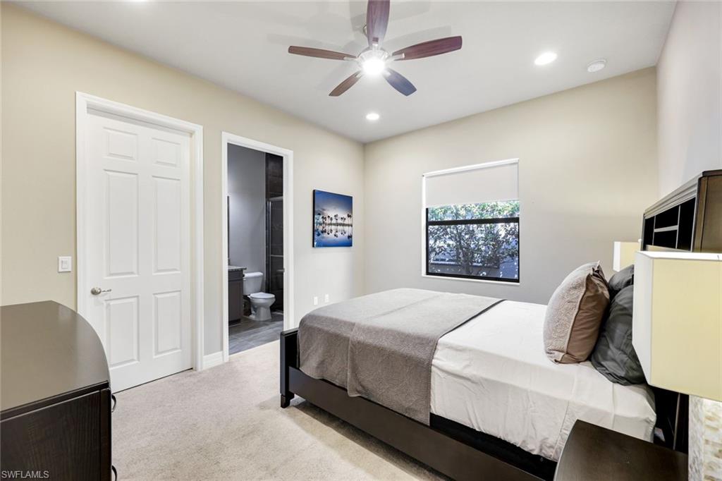 4394 Caldera Circle Naples, FL 34119 - Photo 23 of 39 a bedroom with a large bed a chandelier and a window