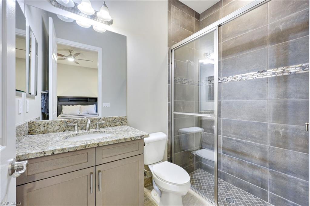 4394 Caldera Circle Naples, FL 34119 - Photo 24 of 39 a bathroom with a granite countertop sink toilet and shower