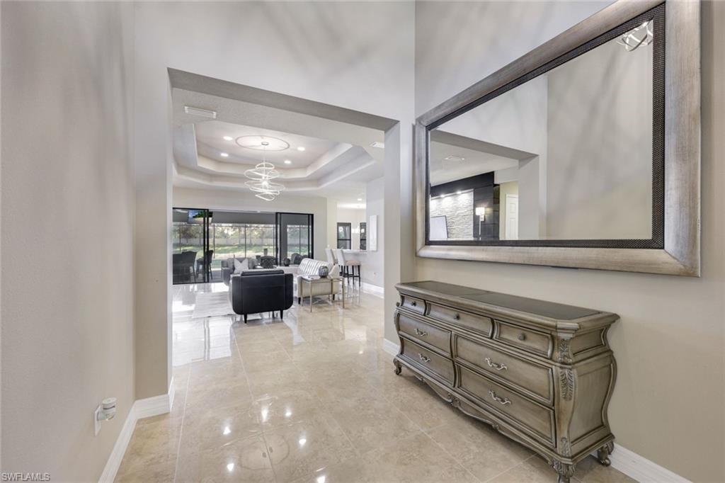 4394 Caldera Circle Naples, FL 34119 - Photo 3 of 39 a living room with furniture and a flat screen tv