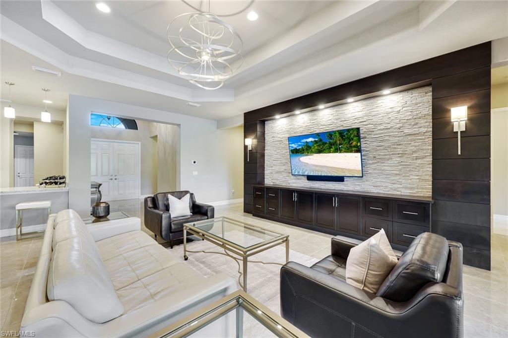 4394 Caldera Circle Naples, FL 34119 - Photo 5 of 39 a living room with furniture and a flat screen tv