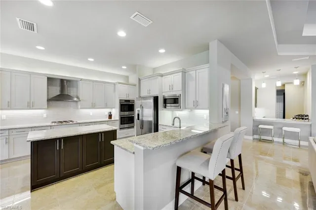 a large kitchen with kitchen island a dining table chairs and white cabinets
