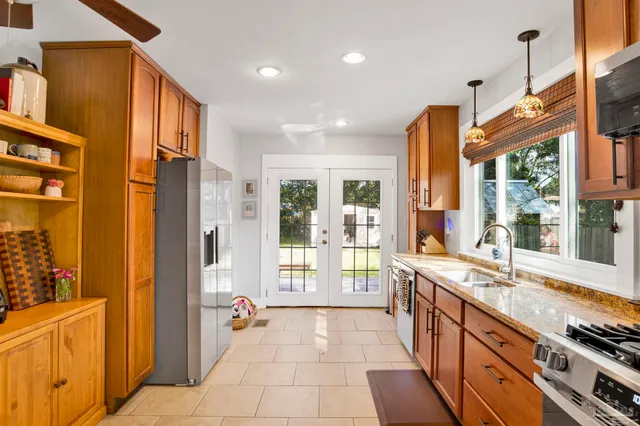a large kitchen with stainless steel appliances granite countertop a large window and a counter top space