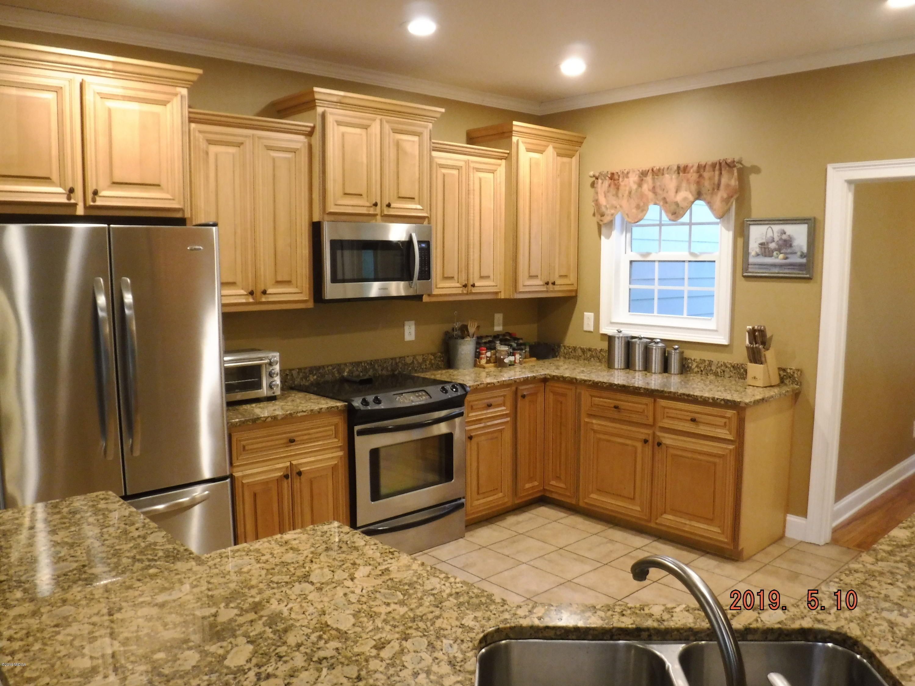 755 Charles Johnson Road Forsyth, GA 31029 - Photo 6 of 35 a kitchen with granite countertop a refrigerator stove top oven and sink