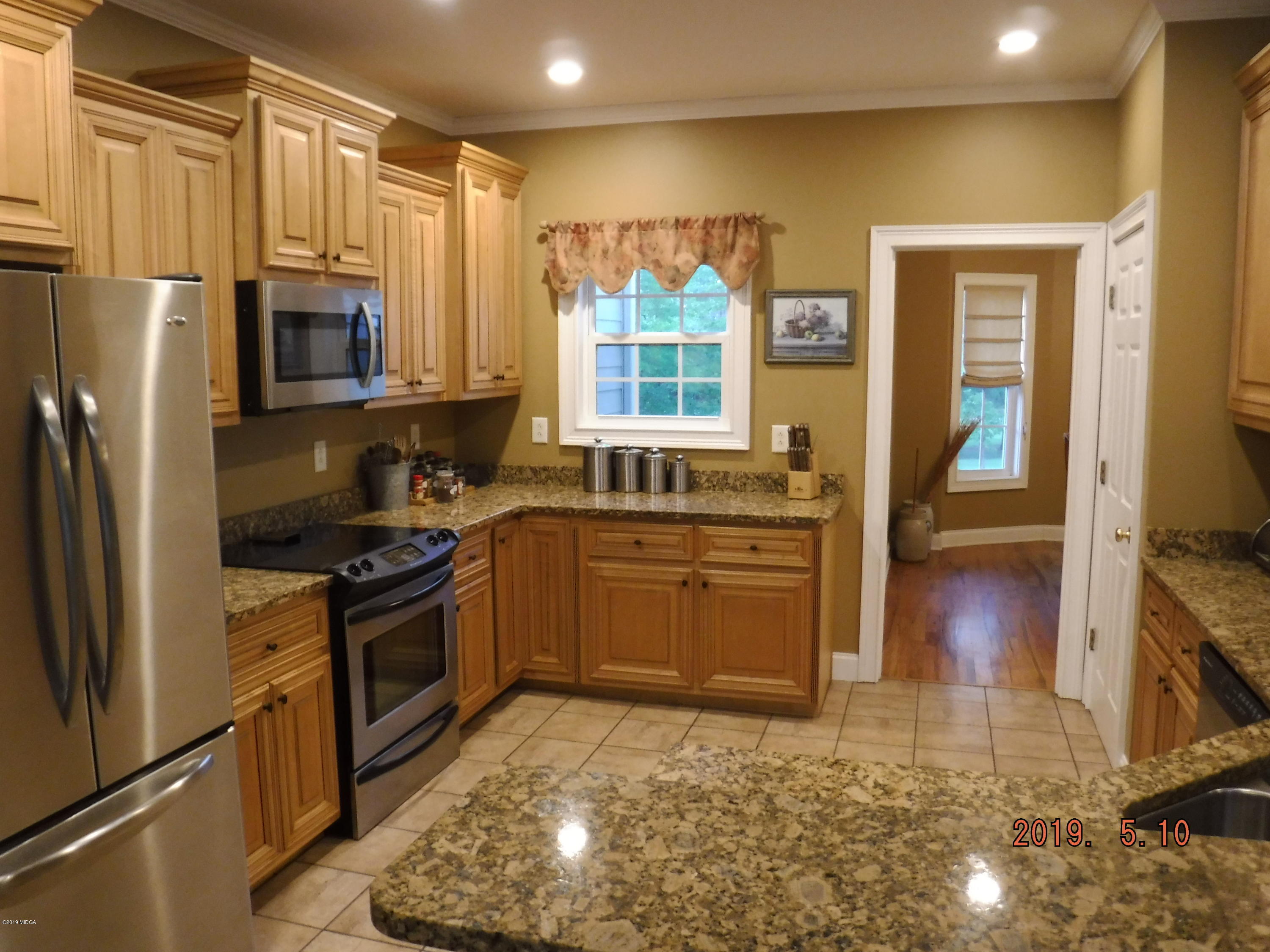 755 Charles Johnson Road Forsyth, GA 31029 - Photo 7 of 35 a kitchen with stainless steel appliances granite countertop a stove a sink and a refrigerator