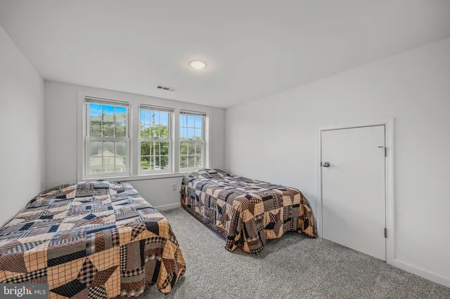 a bedroom with two beds and a window