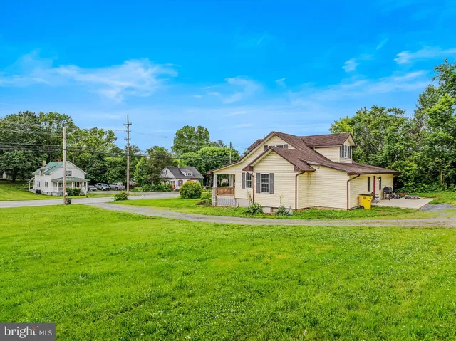 a front view of a house with a yard and trees