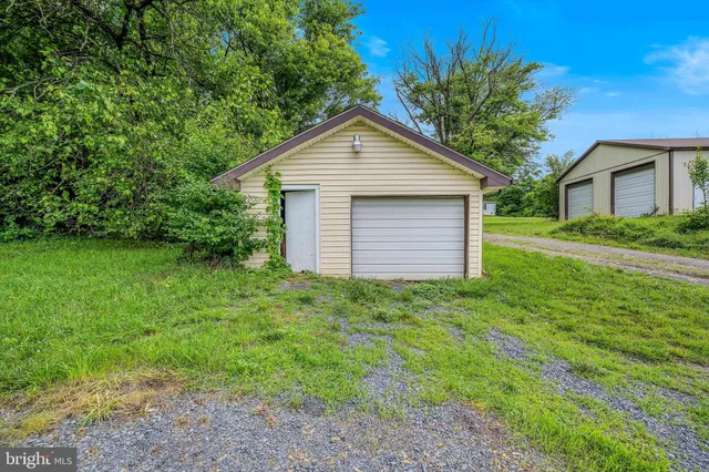 a view of a backyard with barn and large trees