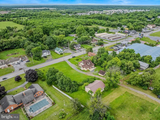 an aerial view of a residential houses with outdoor space and street view