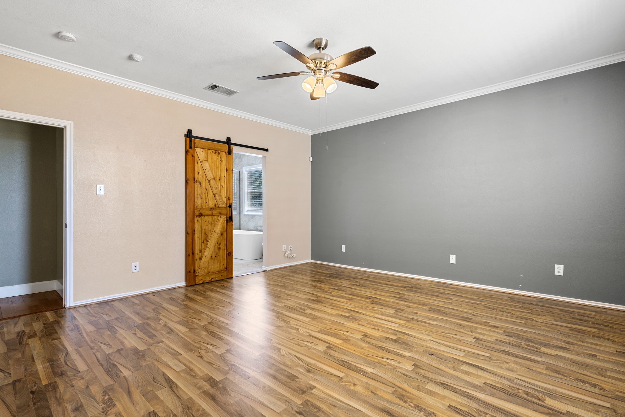 108 Colt Loop Kyle, TX 78640 - Photo 12 of 33 Primary bedroom with barn wood sliding door that opens to the bathroom.