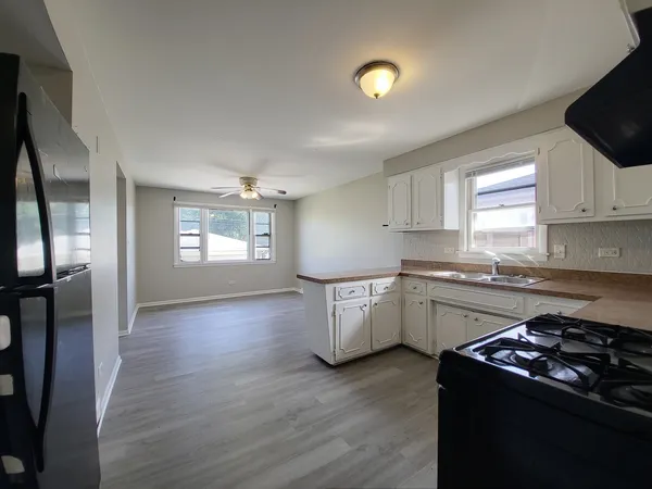 a kitchen with granite countertop a sink stove and refrigerator