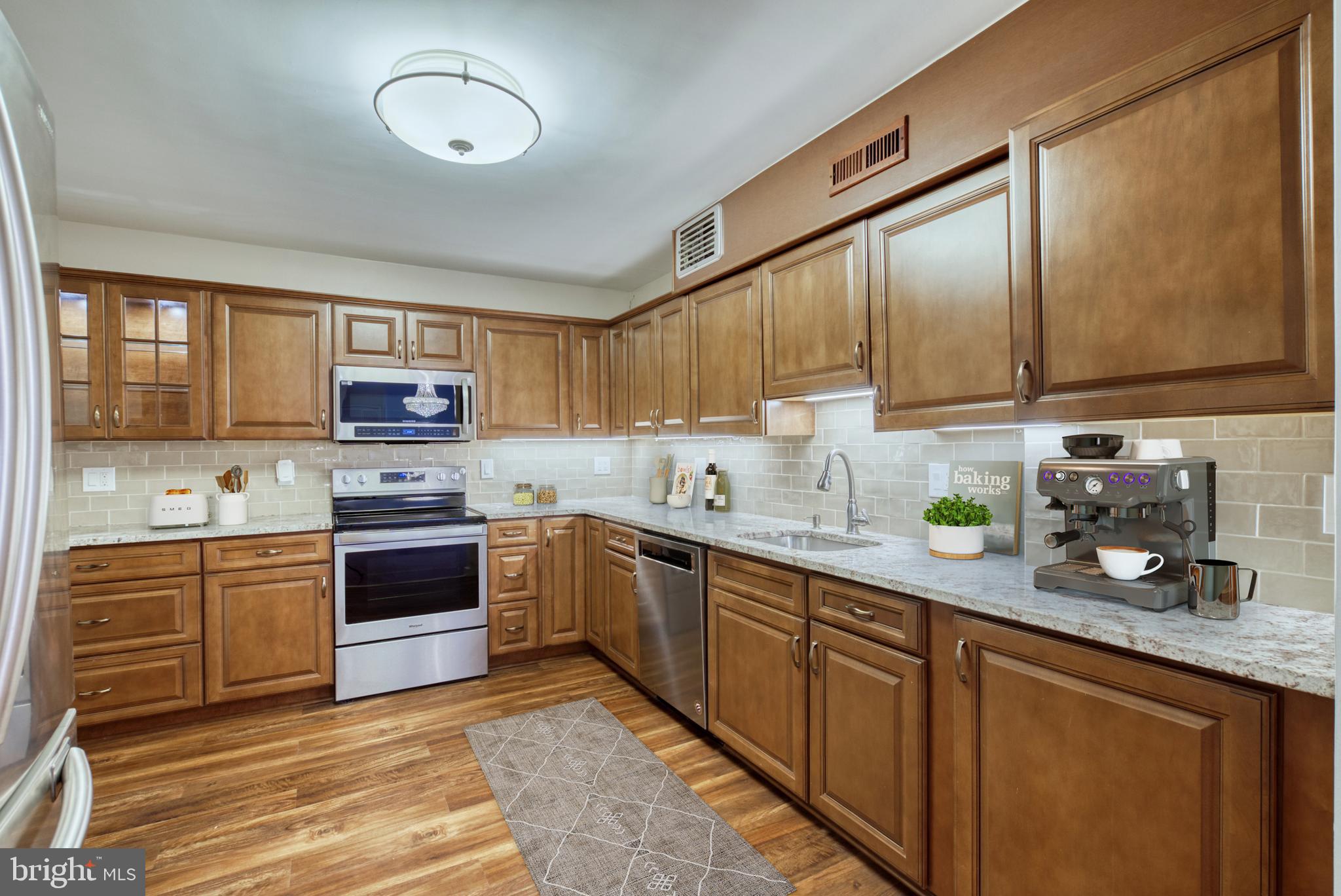 1800 Old Meadow Road, Unit 1006 McLean, VA 22102 - Photo 11 of 63 a kitchen with stainless steel appliances granite countertop a stove sink and cabinets