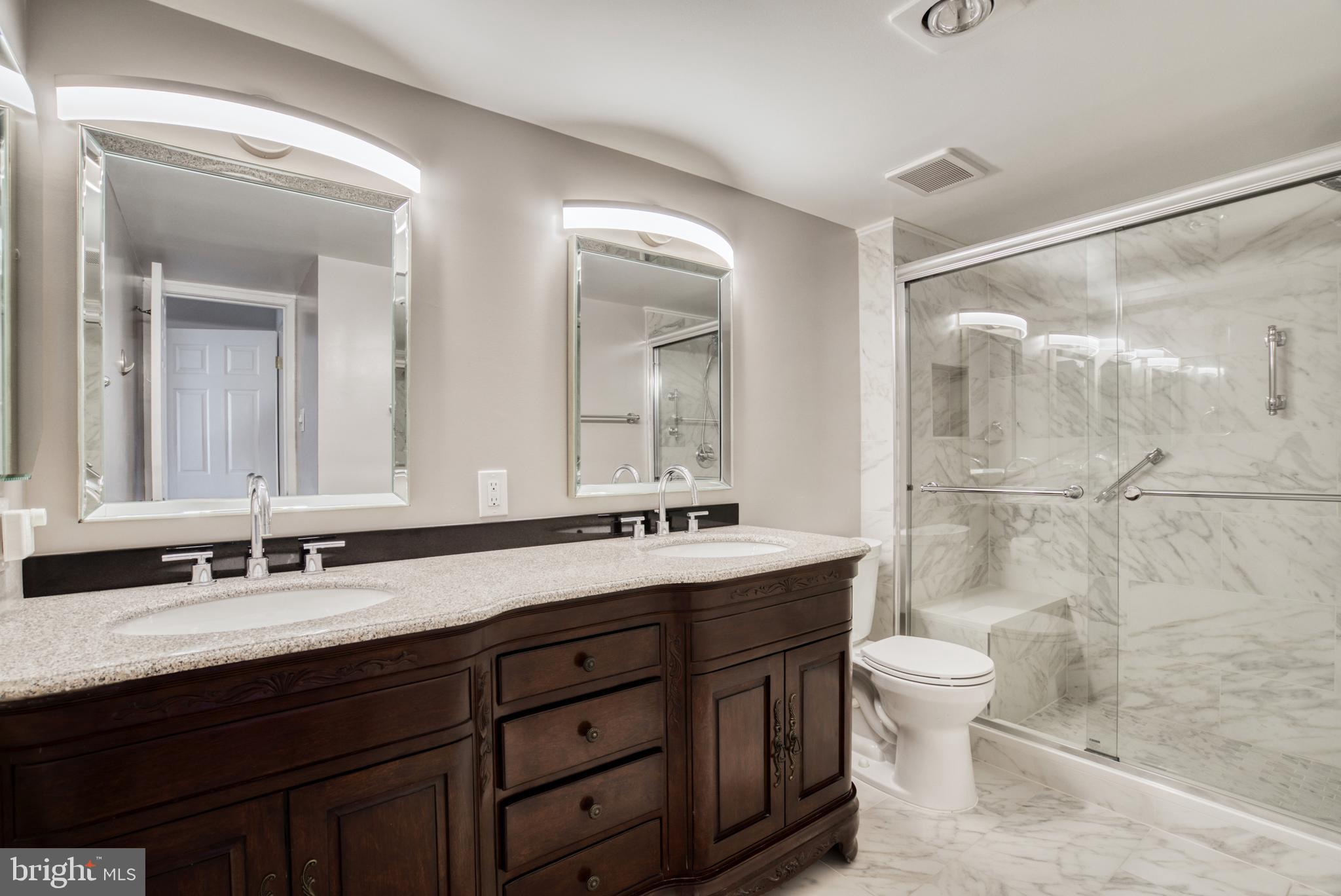 1800 Old Meadow Road, Unit 1006 McLean, VA 22102 - Photo 15 of 63 a bathroom with double vanity sinks a toilet a mirror and shower