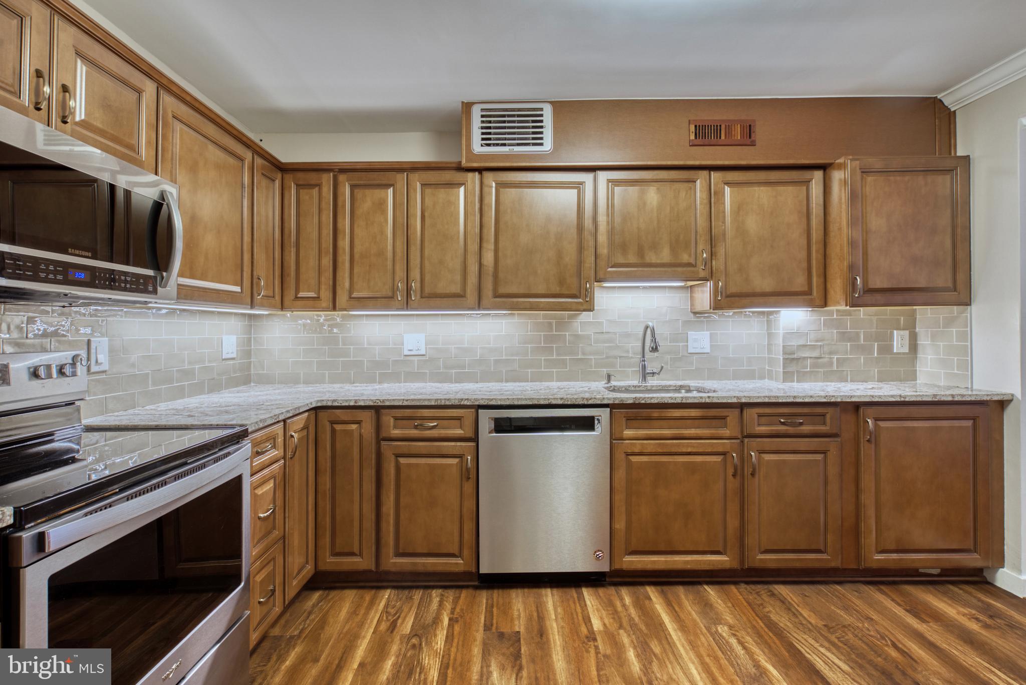 1800 Old Meadow Road, Unit 1006 McLean, VA 22102 - Photo 10 of 63 a kitchen with stainless steel appliances granite countertop a stove a sink and a microwave