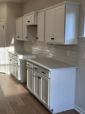 a kitchen with stainless steel appliances granite countertop a stove and a white cabinets