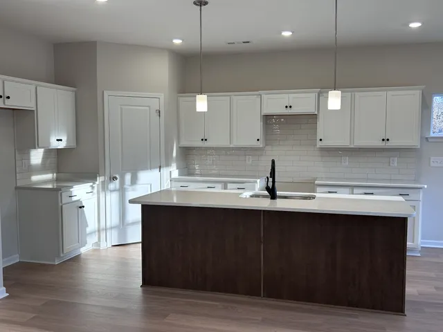 a kitchen with stainless steel appliances granite countertop a sink a stove and a refrigerator