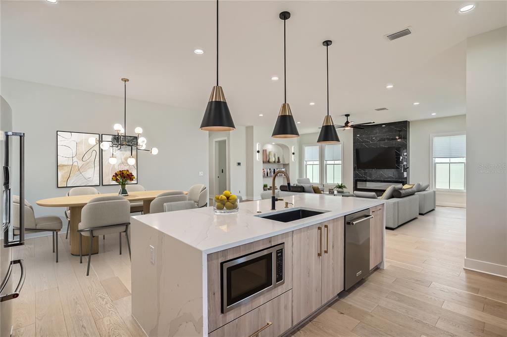 325 33rd Avenue North St. Petersburg, FL 33704 - Photo 13 of 57 a kitchen with stainless steel appliances kitchen island granite countertop a sink a stove and a wooden floors