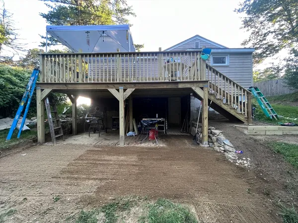 a view of a wooden deck with furniture and a yard