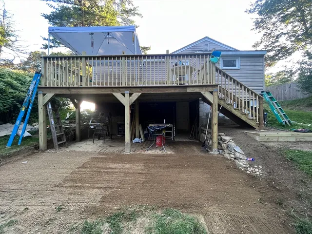 a view of a wooden deck with furniture and a yard