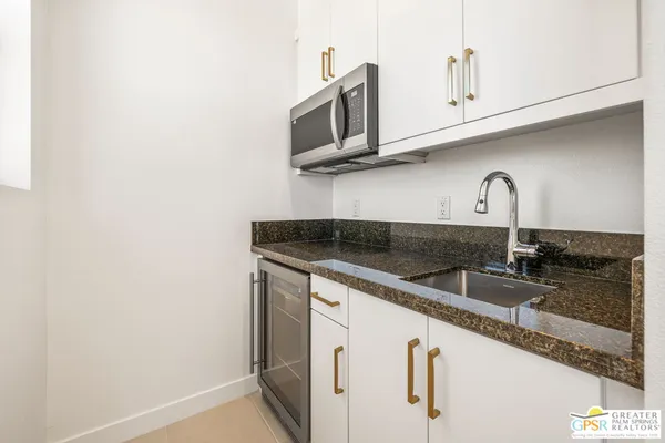 a kitchen with granite countertop a sink and a microwave