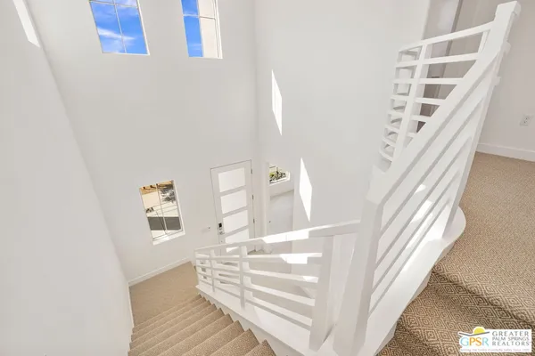 a view of staircase with white walls and a window
