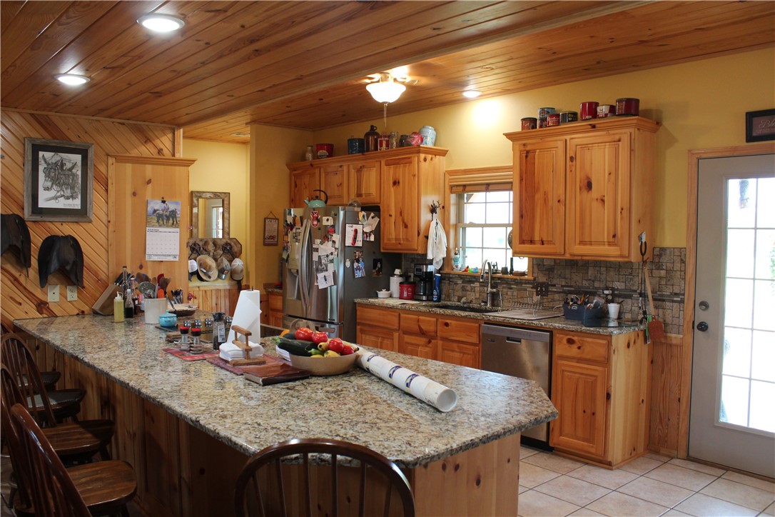 2210 Weiterer Road Scranton, AR 72863 - Photo 17 of 49 Kitchen featuring a spacious island with a granite-style countertop, pine wood-paneled ceiling, recessed lighting, and tile flooring