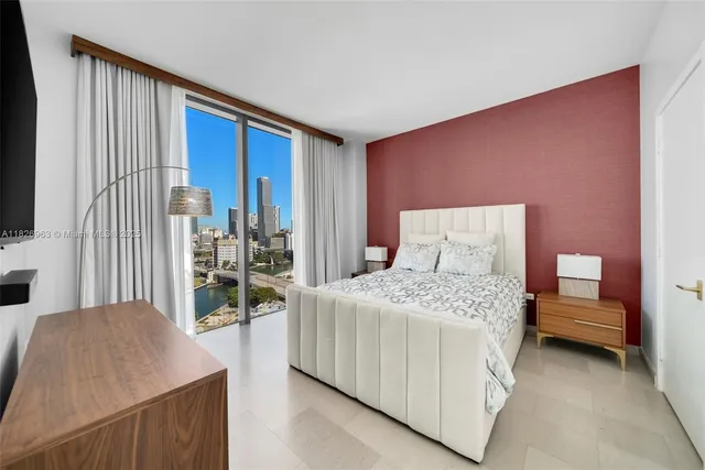 a bedroom with a bed and a flat tv screen