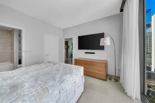 a bedroom with a bed and a flat screen tv